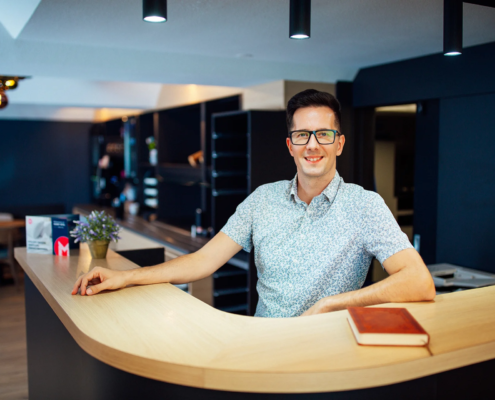 EIn Mitarbeiter steht an der Rezeption