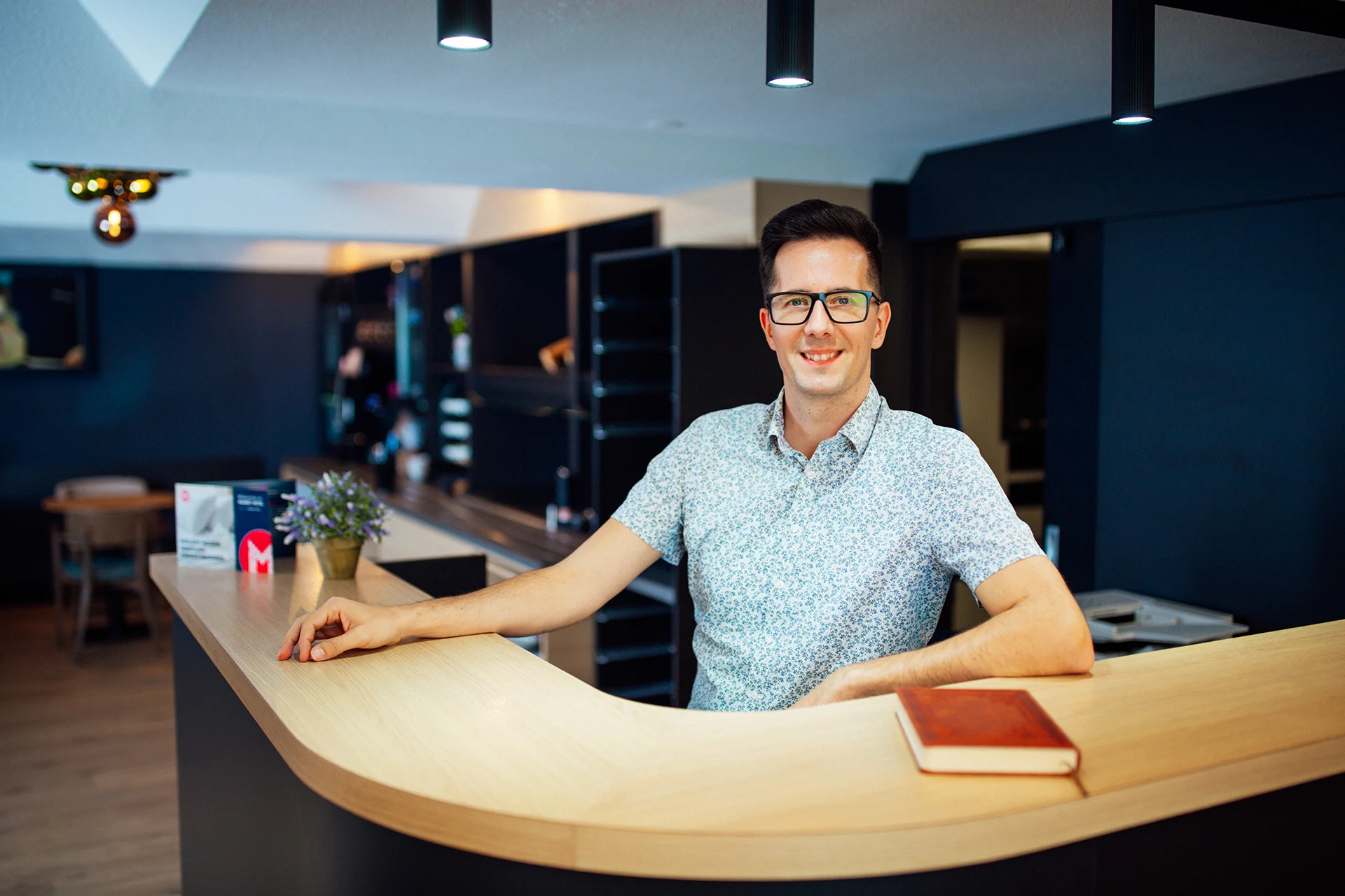 EIn Mitarbeiter steht an der Rezeption